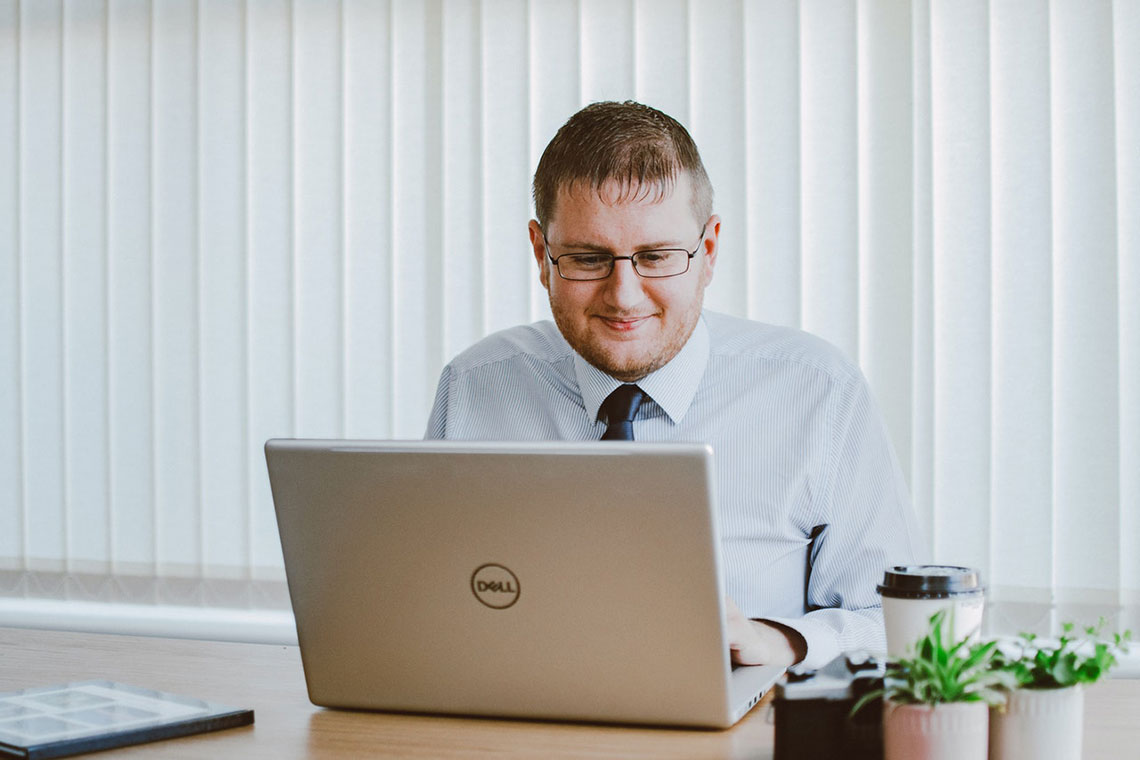 A Happy Businessman Stares at a Computer Screen