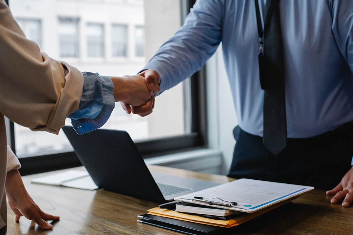 An employee shakes hands with a debt collection agent