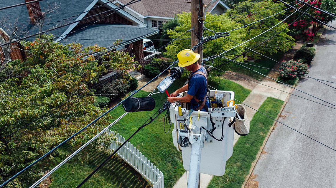 man fixing an hydro cable in a boom lift