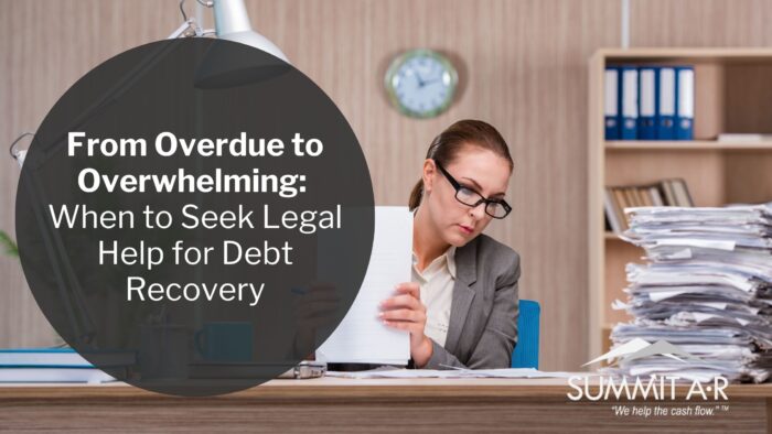 A businesswoman overwhelmed by paperwork sits at her desk reviewing documents, symbolizing the stress of overdue debts and the need for legal help with debt recovery, featured by Summit AR.