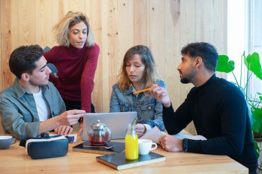 Four business people collaborate in a meeting over breakfast at a restaurant