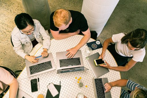 group of women tech workers around a desk, collaborating