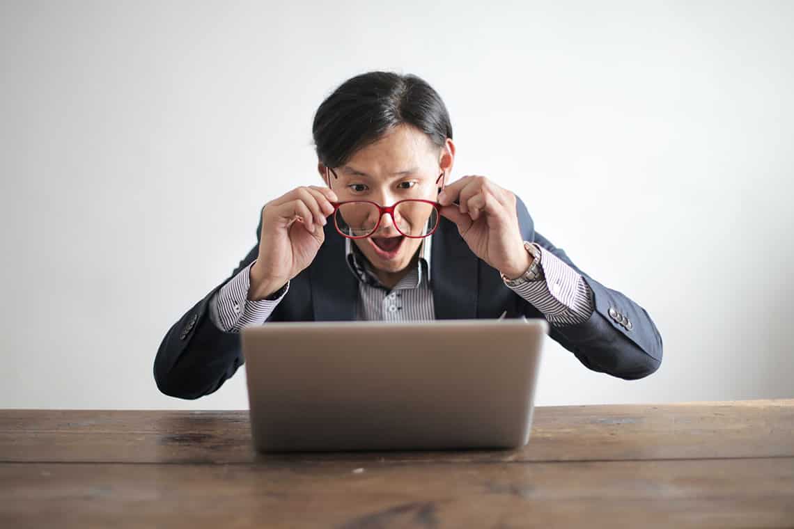 man in a suit, angrily screaming at a laptop screen