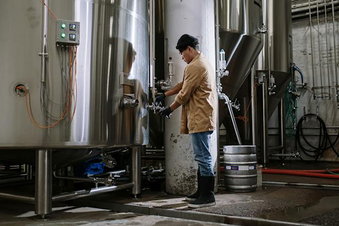 man in brown standing in front of industrial equipment