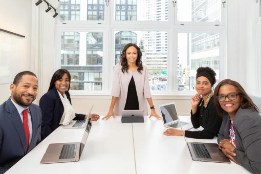small board meeting, 5 professionals looking at the camera