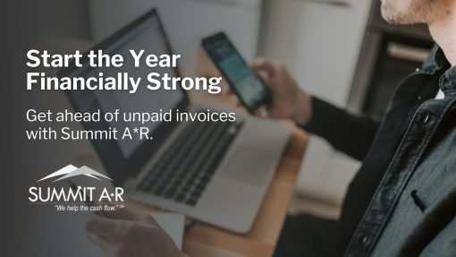 Business professional reviewing unpaid invoices on laptop and phone to improve cash flow at the start of the year