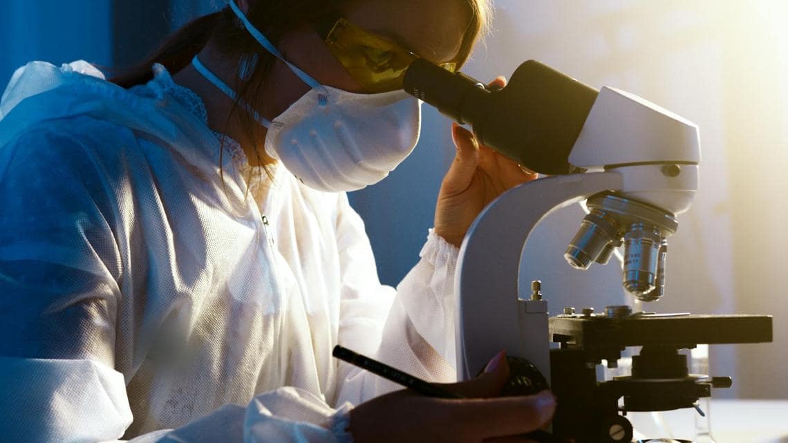 Woman looking through a microscope